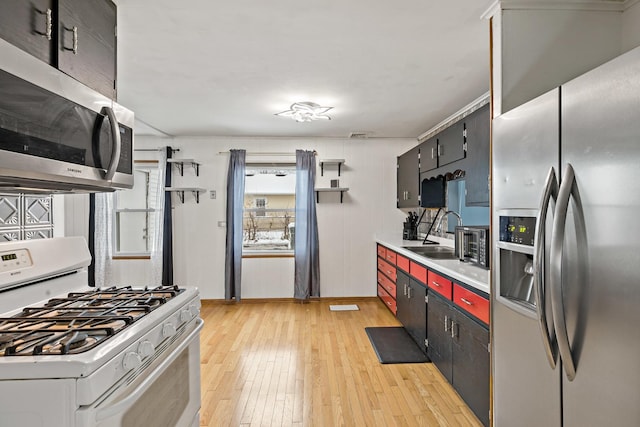 kitchen with light hardwood / wood-style floors, appliances with stainless steel finishes, and sink