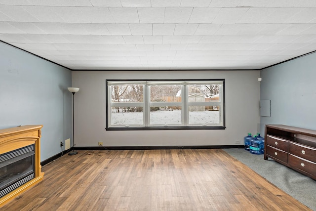 unfurnished living room featuring ornamental molding and hardwood / wood-style floors