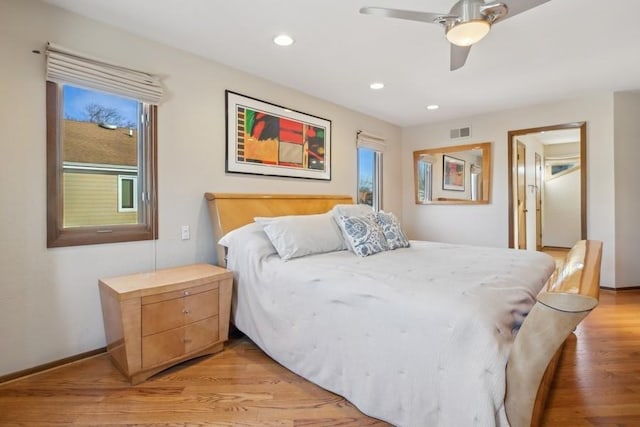 bedroom with ceiling fan, multiple windows, and light wood-type flooring