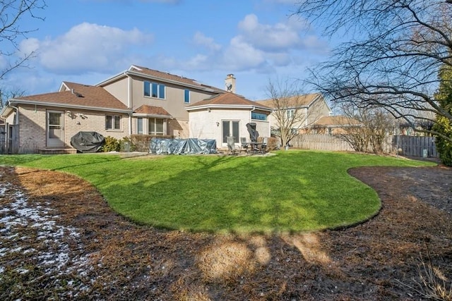 rear view of house featuring a yard