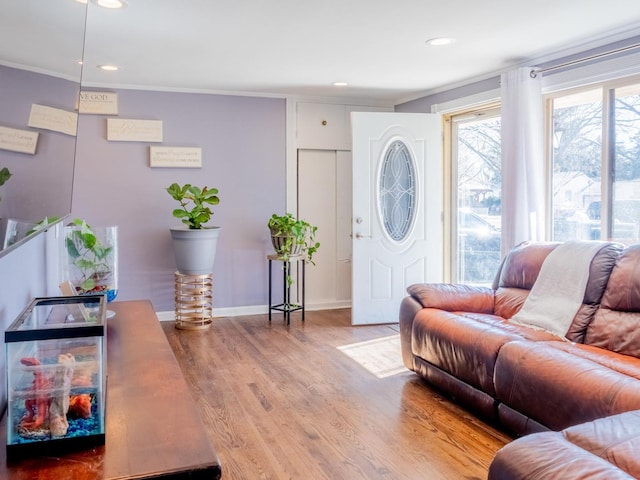 living room with recessed lighting, ornamental molding, baseboards, and wood finished floors