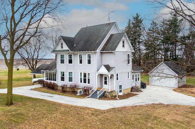 view of front facade featuring a garage, an outdoor structure, and a front lawn