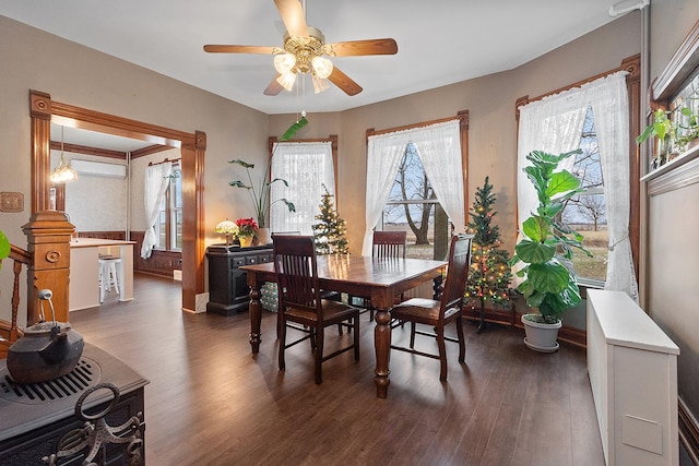 dining space with ceiling fan and dark wood-type flooring