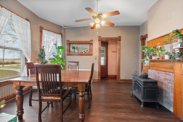 dining room featuring a wood stove, ceiling fan, and dark hardwood / wood-style flooring