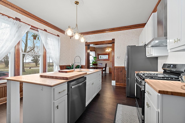 kitchen with a kitchen island with sink, white cabinets, pendant lighting, and appliances with stainless steel finishes