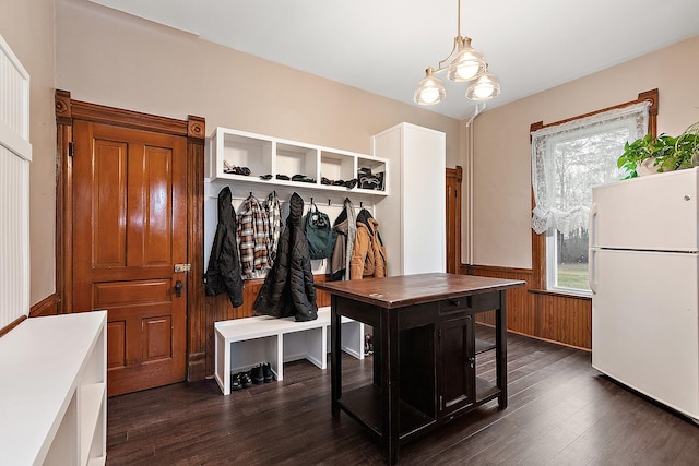 mudroom with wooden walls, a healthy amount of sunlight, dark hardwood / wood-style floors, and a notable chandelier