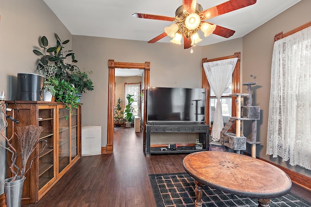 living room with dark hardwood / wood-style floors and ceiling fan