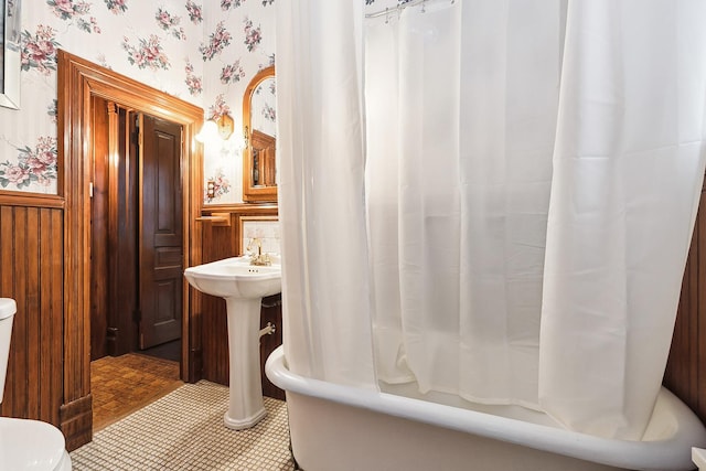 bathroom with tile patterned floors, toilet, and shower / tub combo with curtain