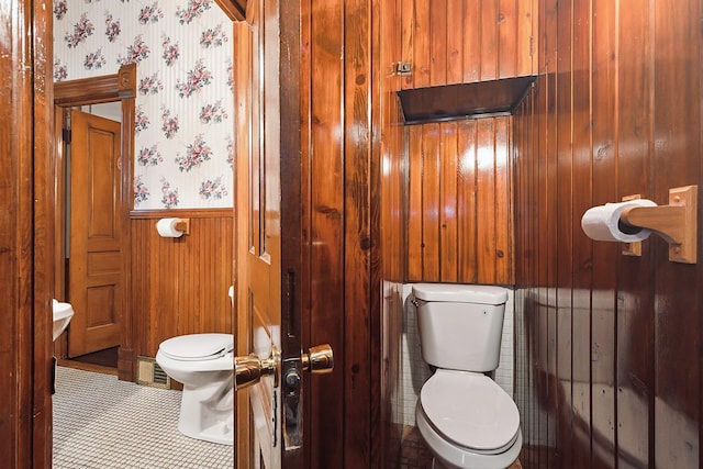 bathroom with wooden walls, tile patterned flooring, and toilet