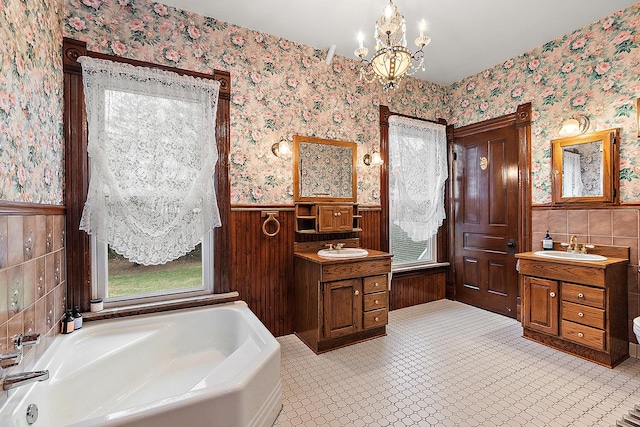 bathroom with vanity, a tub to relax in, and a chandelier