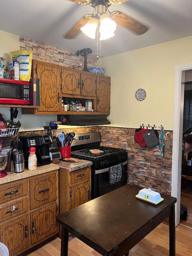 kitchen featuring light hardwood / wood-style flooring, stainless steel electric stove, and ceiling fan