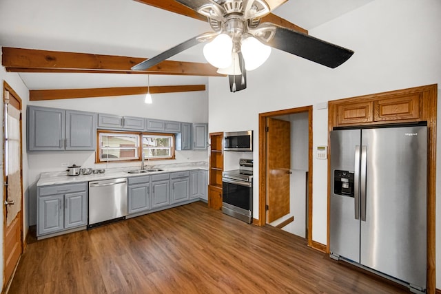 kitchen with stainless steel appliances, ceiling fan, sink, vaulted ceiling with beams, and gray cabinets