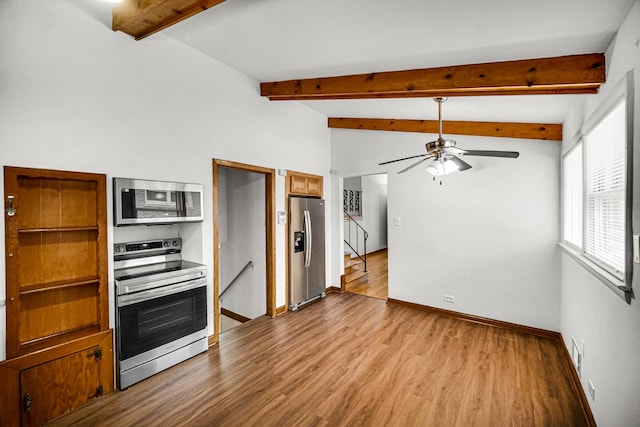 kitchen with vaulted ceiling with beams, ceiling fan, light hardwood / wood-style floors, and stainless steel appliances