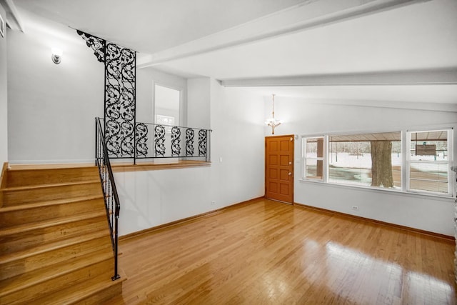 unfurnished room featuring wood-type flooring and lofted ceiling with beams