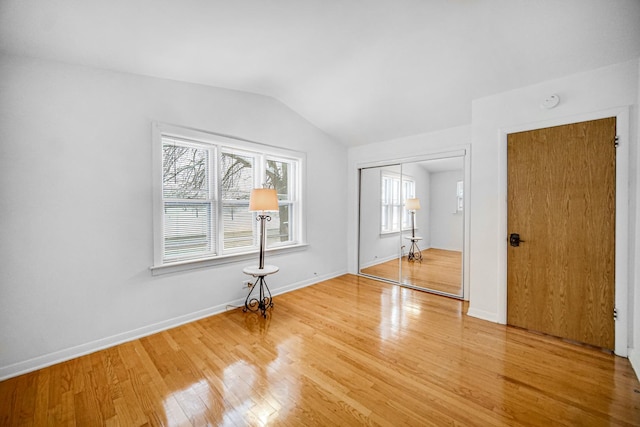 spare room with hardwood / wood-style floors and lofted ceiling