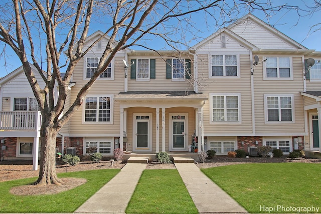 view of property featuring central AC and a front lawn