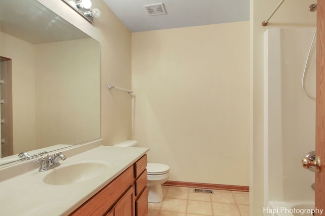 bathroom featuring tile patterned floors, vanity, toilet, and walk in shower