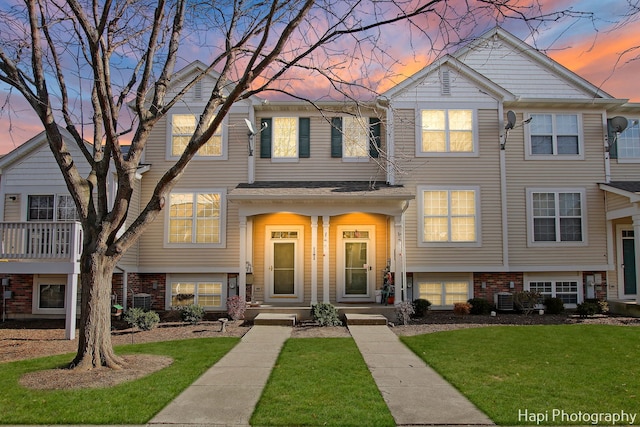 view of front of house with a lawn and cooling unit