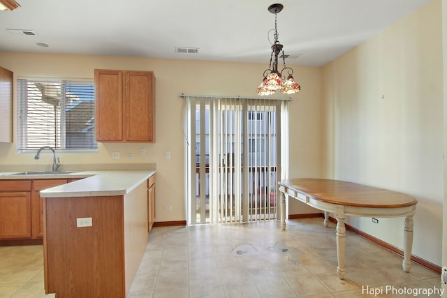 kitchen with light tile patterned floors, hanging light fixtures, a notable chandelier, and sink