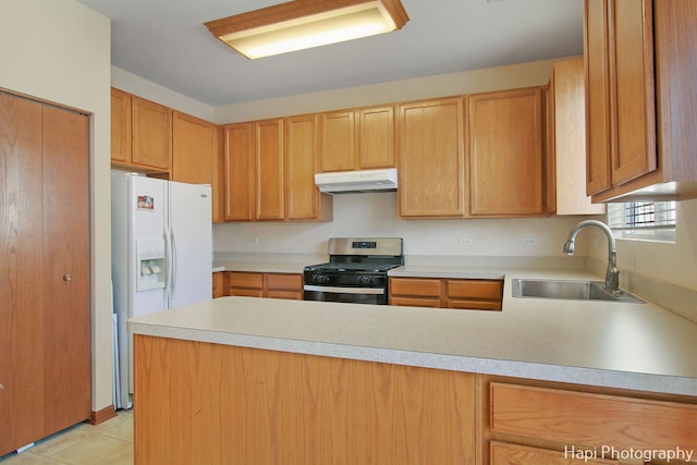 kitchen featuring sink, stainless steel gas range, white fridge with ice dispenser, light tile patterned floors, and kitchen peninsula