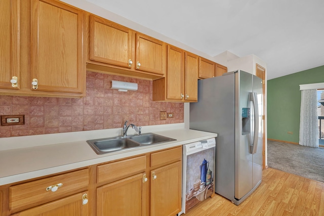 kitchen featuring backsplash, sink, appliances with stainless steel finishes, and light hardwood / wood-style flooring