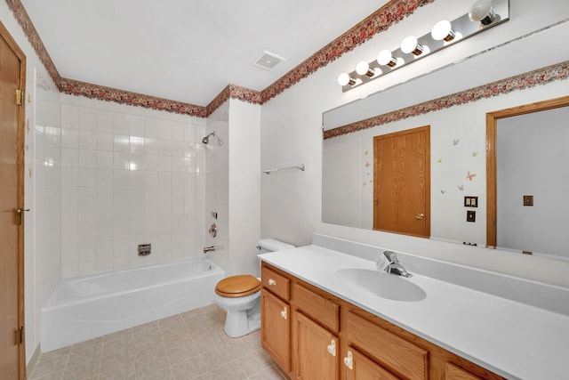 full bathroom with vanity, tiled shower / bath combo, and toilet