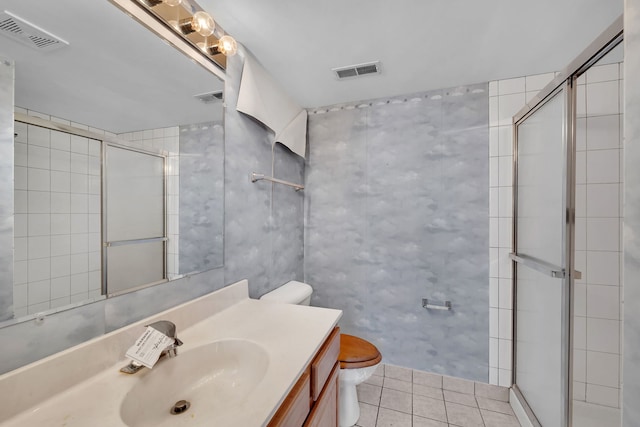 bathroom featuring toilet, vanity, tile patterned floors, and walk in shower