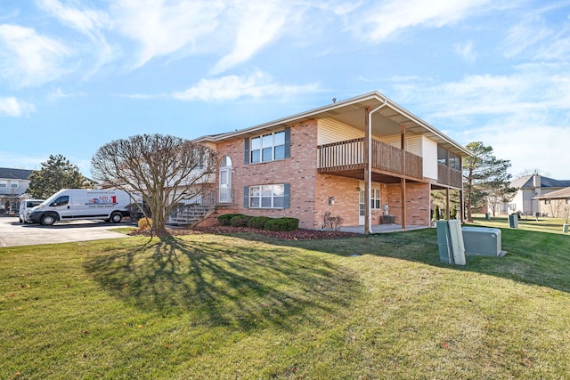 view of side of home featuring a lawn and a balcony