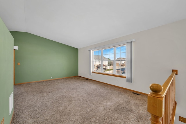 spare room with carpet flooring and lofted ceiling