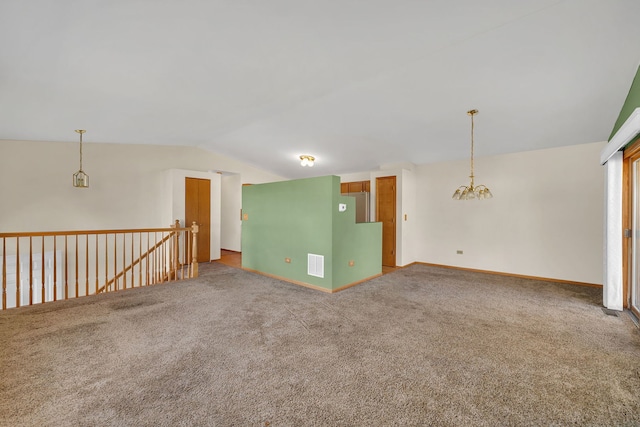 carpeted empty room with an inviting chandelier and vaulted ceiling