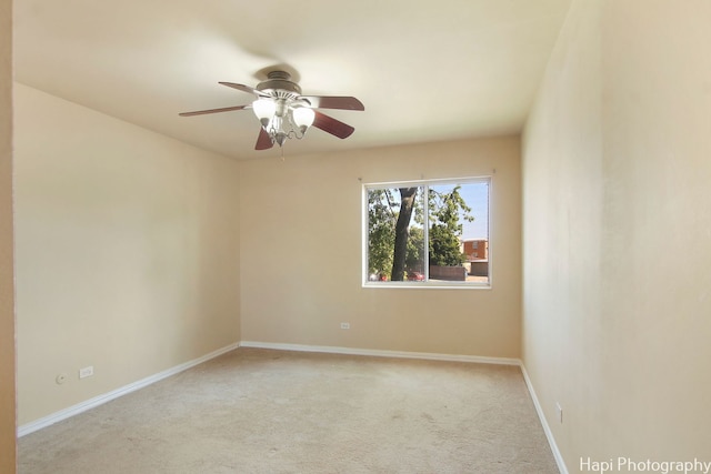 carpeted spare room featuring ceiling fan