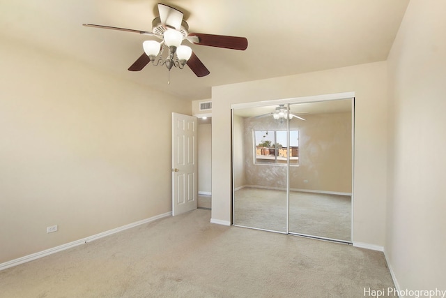 unfurnished bedroom featuring ceiling fan, a closet, and light colored carpet