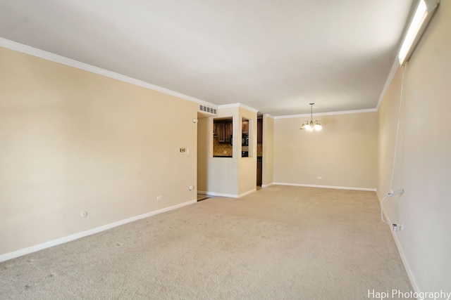 carpeted empty room with ornamental molding and a chandelier