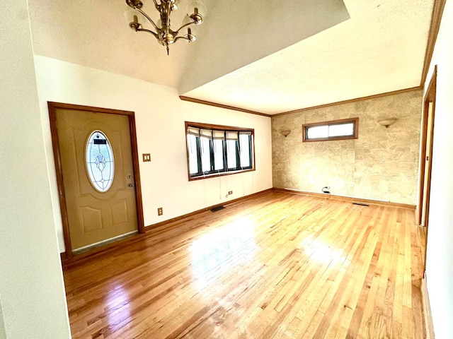 entryway with hardwood / wood-style flooring, a wealth of natural light, and ornamental molding