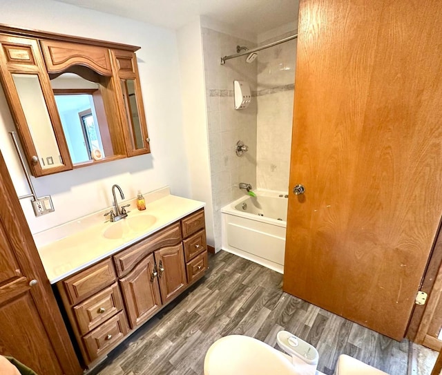 full bathroom with vanity, toilet, tiled shower / bath, and wood-type flooring