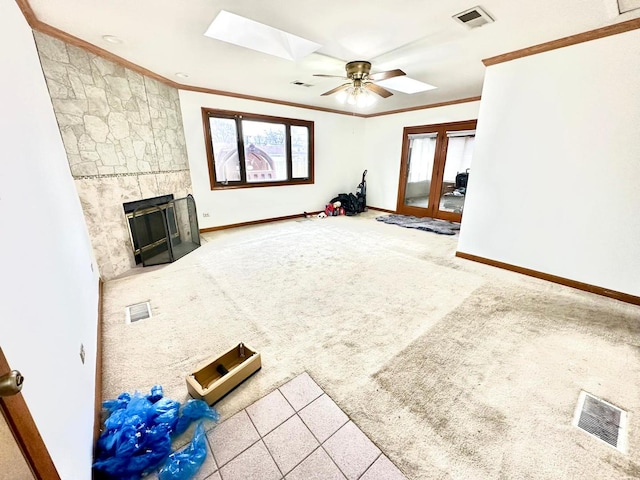 living room with a skylight, a wealth of natural light, a tile fireplace, and carpet