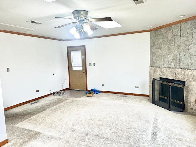 unfurnished living room with ceiling fan, carpet, crown molding, and a tiled fireplace