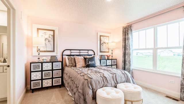 bedroom with light colored carpet and a textured ceiling