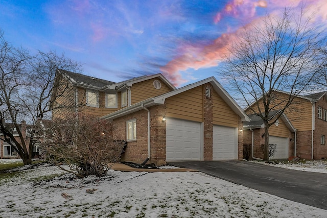 snow covered property featuring a garage