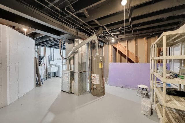 basement featuring gas water heater, heating unit, and sink