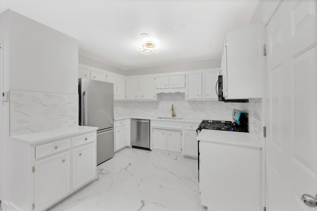 kitchen with white cabinets, backsplash, sink, and stainless steel appliances