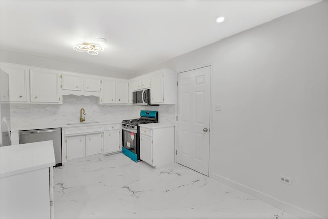 kitchen with backsplash, white cabinetry, sink, and appliances with stainless steel finishes