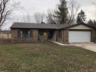 ranch-style house featuring a garage and a front lawn