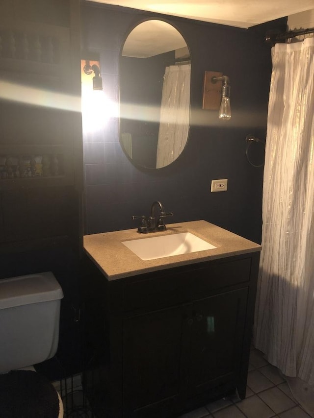 bathroom with tile patterned flooring, vanity, and toilet