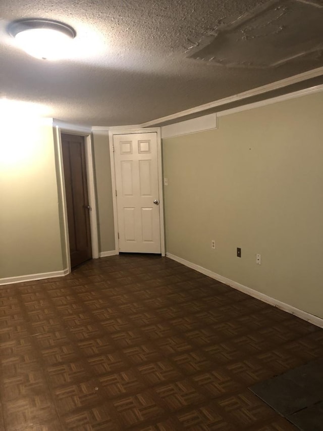 unfurnished room featuring dark parquet floors and a textured ceiling