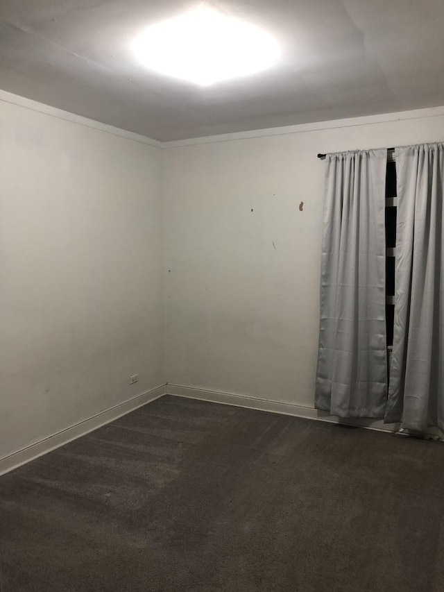 unfurnished room featuring dark colored carpet