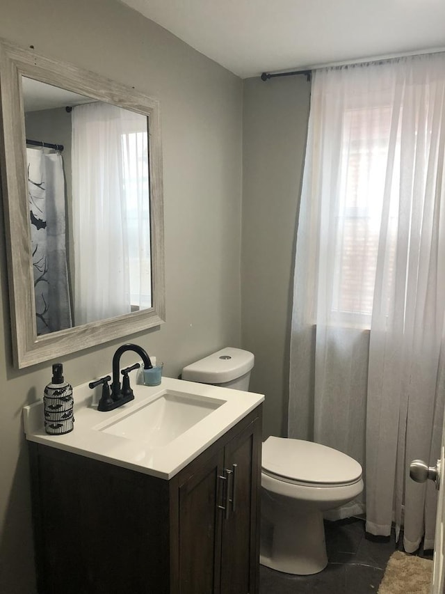 bathroom with tile patterned flooring, vanity, and toilet