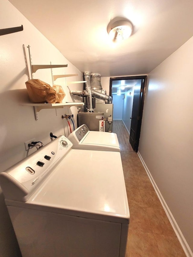 laundry area with dark tile patterned floors and washing machine and clothes dryer