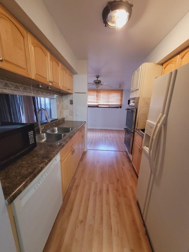 kitchen with light wood-type flooring, backsplash, white appliances, ceiling fan, and sink