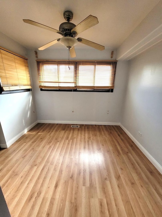 spare room with ceiling fan and light wood-type flooring